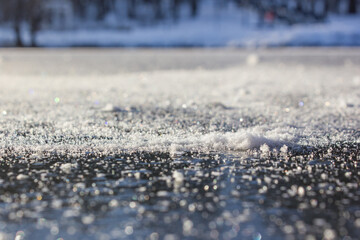 Close-up of snow flakes on the clear first ice on the river