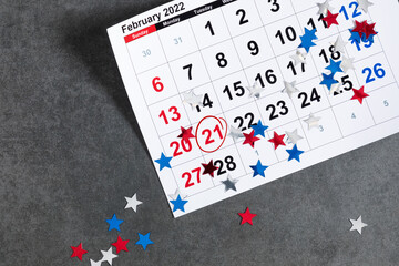 Presidents Day. Date on calendar February 21, Red, blue and white star confetti, decorations on...