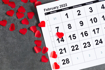 Valentines day background. Office table. Date February 14 on calendar 2022, Valentine's Day red heart circled. Flat lay, top view, copy space 