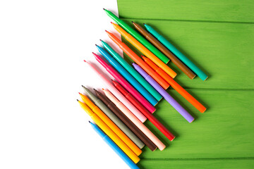 White paper and markers with green background. Place for text or logo.