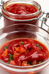 Tomato sauce in glass bowl and jar.