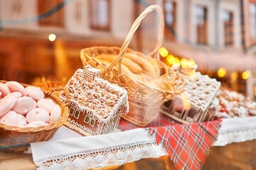 A bakery showcase in a European city for Christmas. Gingerbread house, pretzel, apple crumble, buns. Bread on Christmas and New year
