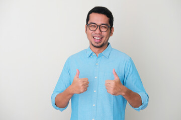 Happy Asian man giving two thumbs up - Powered by Adobe