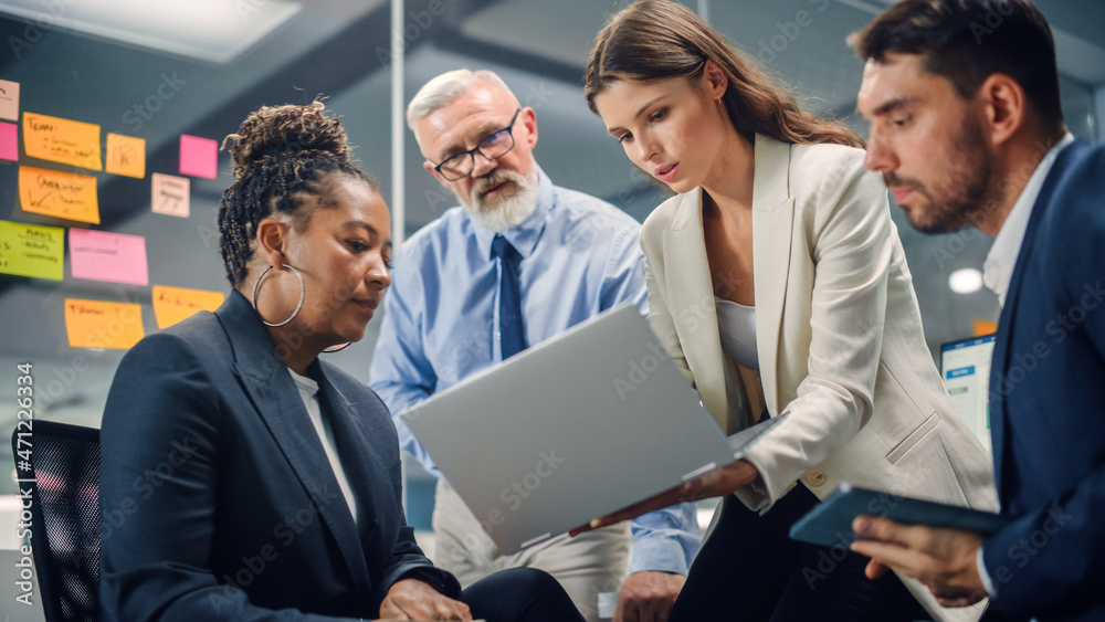 Aufkleber in modern office: diverse team of managers use laptop and tablet computers at a company meeting disc