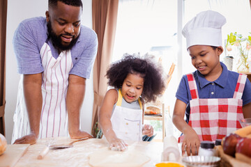 African American family help prepare the flour for making cookies. Happy African American family