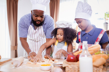 Obraz na płótnie Canvas African American family help prepare the flour for making cookies. Happy African American family