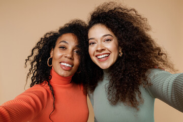 Close up two cheerful happy beautiful young curly black women friends 20s wearing casual shirts...