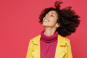 Charming bright happy young curly black latin woman 20s years old wears yellow jacket dance waving fooling around have fun enjoy play fluttering hair isolated on plain red background studio portrait.