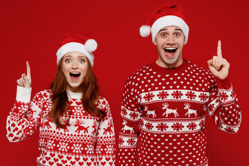 Young couple friend two man woman 20s in sweater hat holding index finger up with great new idea...