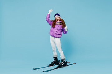 Full body skier happy fun cool woman 20s wearing warm purple padded windbreaker jacket ski goggles...