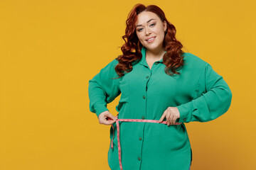 Smiling bright happy fun young ginger chubby overweight woman 20s years old wears green shirt hold...