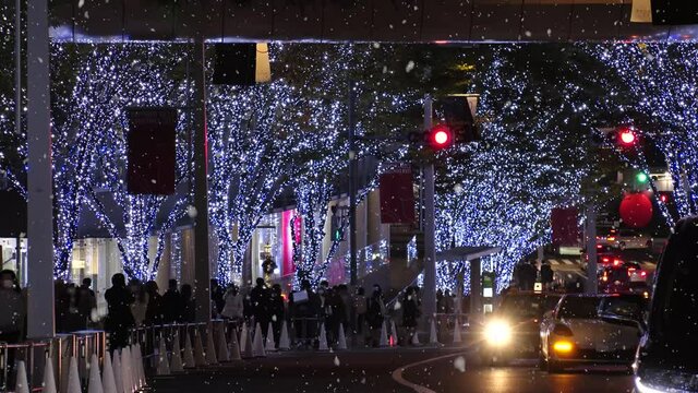 TOKYO, JAPAN - NOV 2021 : Christmas illumination, led light up and snow at Roppongi Keyaki-zaka (Keyaki hill). Scenery of downtown city and street at night. Winter and Christmas season concept.