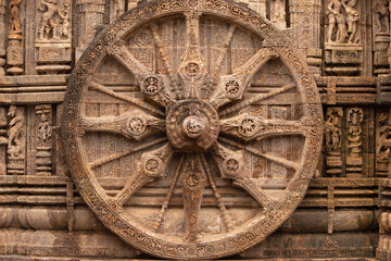 Fototapeta na wymiar Chariot wheel with eight spokes with a central medallion. The medallions on the wheel spokes are richly carved depicting numerous deities and erotic and amorous figures Konark Sun Temple, Orissa