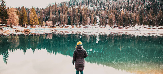 woman watchin amazing turquoise water of Caumasee in winter Switzerland slow travel