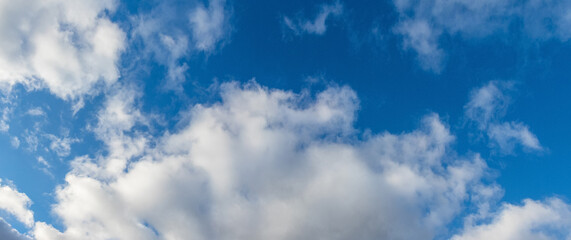 Big white fluffy cloud in the blue sky in sunny weather