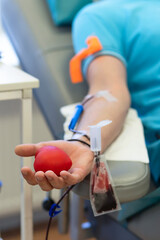 bone marrow donation. male hand holding red ball, blood transfusion system, blood bag.  vertical,...