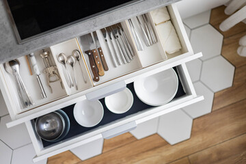 Top view storage organization plate dishes in drawer at modern minimalistic kitchen in Nordic style