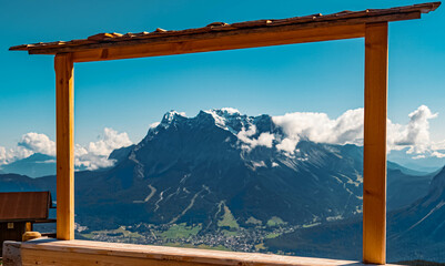 Beautiful alpine summer view with the famous Zugspitze summit, top of germany, in a wooden foto frame seen from the Grubigstein summit near Lermoos, Tyrol, Austria