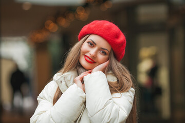 Christmas street style portrait of young beautiful fashion woman walking in European city on winter holidays. Stylish model in casual clothes with long hair is doing New Year's shopping.