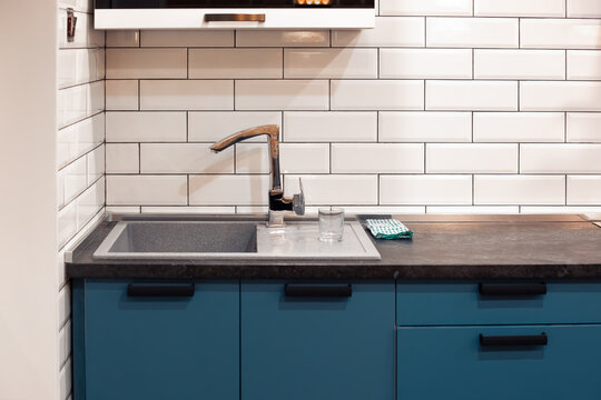 Kitchen Design With White Brick Tiles And A Dark Countertop With A Deep Sink. Home Modern Interior.