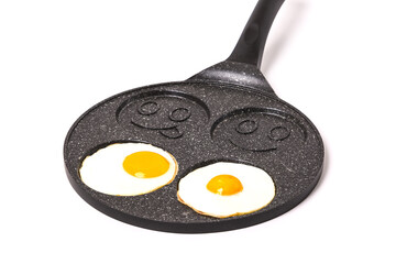 Creative frying pan for frying eggs. Cheerful Smileys.