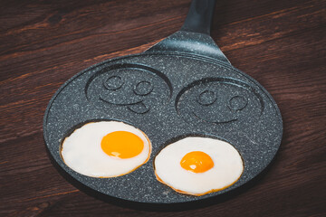 Creative frying pan for frying eggs. Cheerful Smileys