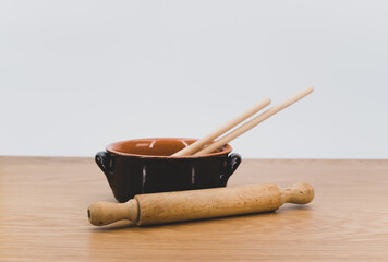 terracotta bowl and natural solid wood kitchen tools on a wooden tabletop