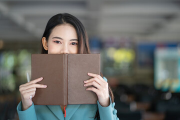 Attractive Asian female office reading a book in the office
