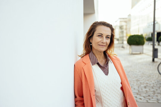 Relaxed fashionable middle aged woman stood outdoors