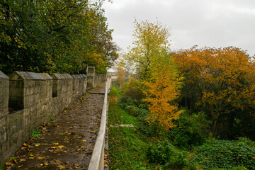 Fototapeta na wymiar Trail on top of medieval 13th century city wall through colorful autumn foliage in York England