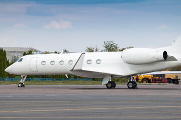 Fototapeta na wymiar Close-up of modern white corporate business jet at the airport apron