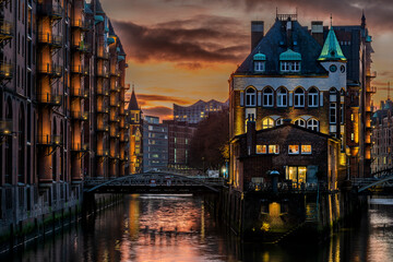 High dynamic and detailed photography of the illuminated Speicherstadt with the Wasserschloss in...