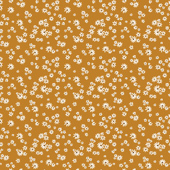 Beautiful floral pattern in small abstract chamomile flowers. Small white flowers. Mustard background. Ditsy print. Floral seamless background. The elegant the template for fashion prints. Stock.
