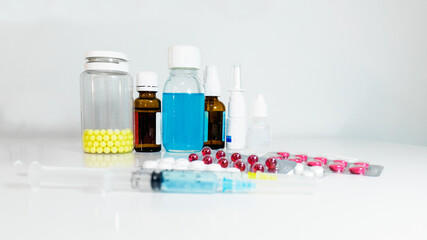 On the table are injecting syringes and various tablets, and in the background are medicinal syrups and also various drops and vitamins. Blurred background. Selective focus.
syringes and injections. M