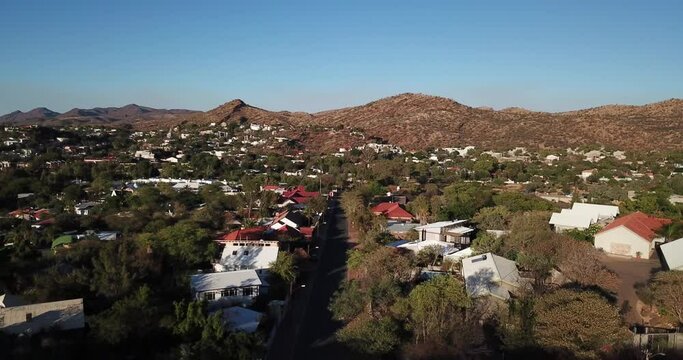 4K aerial Windhoek capital residential central hilly district bright sunset drone video, blooming Jacaranda trees, upmarket houses, old white walls German mansions in Khomas Region, central Namibia