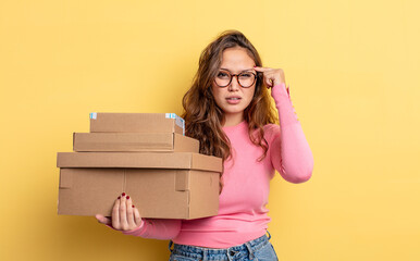 hispanic pretty woman feeling confused and puzzled, showing you are insane. storage concept