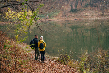 Obraz premium Lovely adult couple, admiring the stillness of the lake, on a mountain.