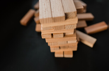 Jenga game. Take out small wooden blocks. Leisure time concept at home