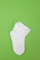 white new small baby socks on green background