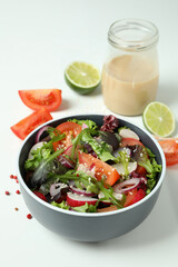 Concept of tasty food with vegetable salad with tahini sauce on white background