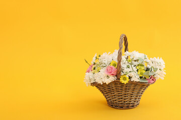 Fototapeta na wymiar Basket with beautiful flowers on yellow background