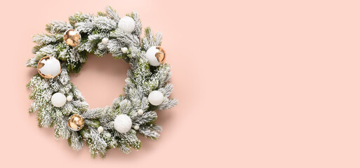 Christmas wreath of snowy branches with white and gold baubles on pink background. New Year greeting card. Top view. Traditional decoration for Xmas holiday in luxury modern style with gold potal.
