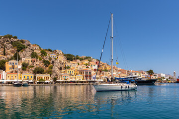 Fototapeta na wymiar Bay with colorful houses on the hillside of the island of Symi. Greece