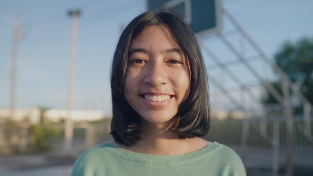 portrait happy Asian girl smile on face at stadium in morning and sunlight