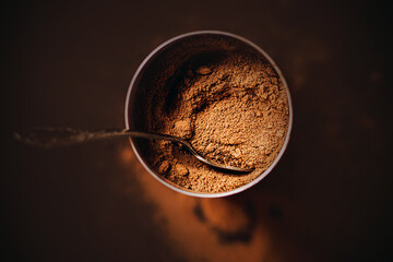 Top view of a jar filled with delicious aromatic natural cocoa powder, which contains a beautiful...
