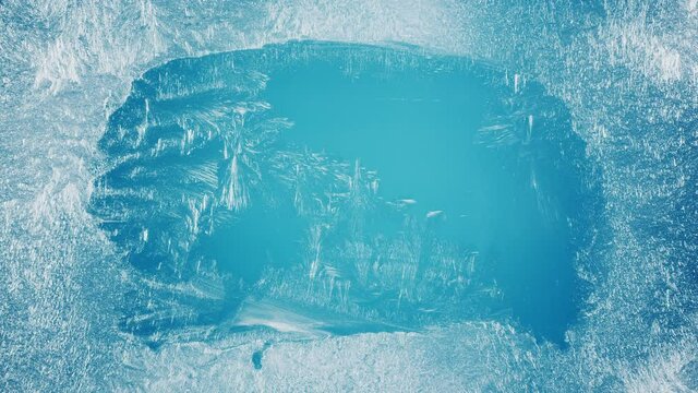 Frozen window with frosty patterns gradually fills with frost over its entire surface. Great background for Christmas and New Years. 