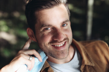 Young handsome man smiling and looking at the camera, park, outdoors