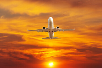 Fototapeta na wymiar Airplane take off in the bright orange sunset sky.
