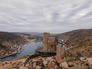 Fototapeta na wymiar An ancient fortress on the top of a mountain by the Black Sea overlooking a quiet harbor.