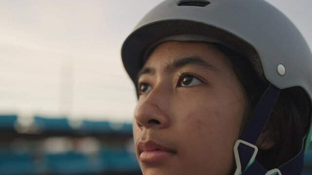 Close-up face of asian woman looking up determinedly and wearing helmet